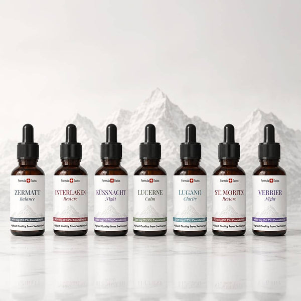 Formula Swiss CBD olie-kollektion med syv ravfarvede pipetteflasker præsenteret foran schweiziske bjerge.